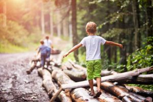 boy balancing on logs